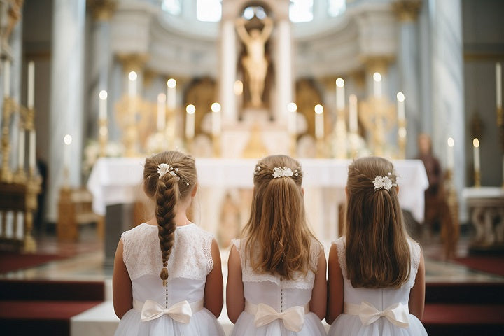 trzy dziewczynki przed ołtarzem podczas pierwszej komunii świętej prezentujące fryzury komunijne