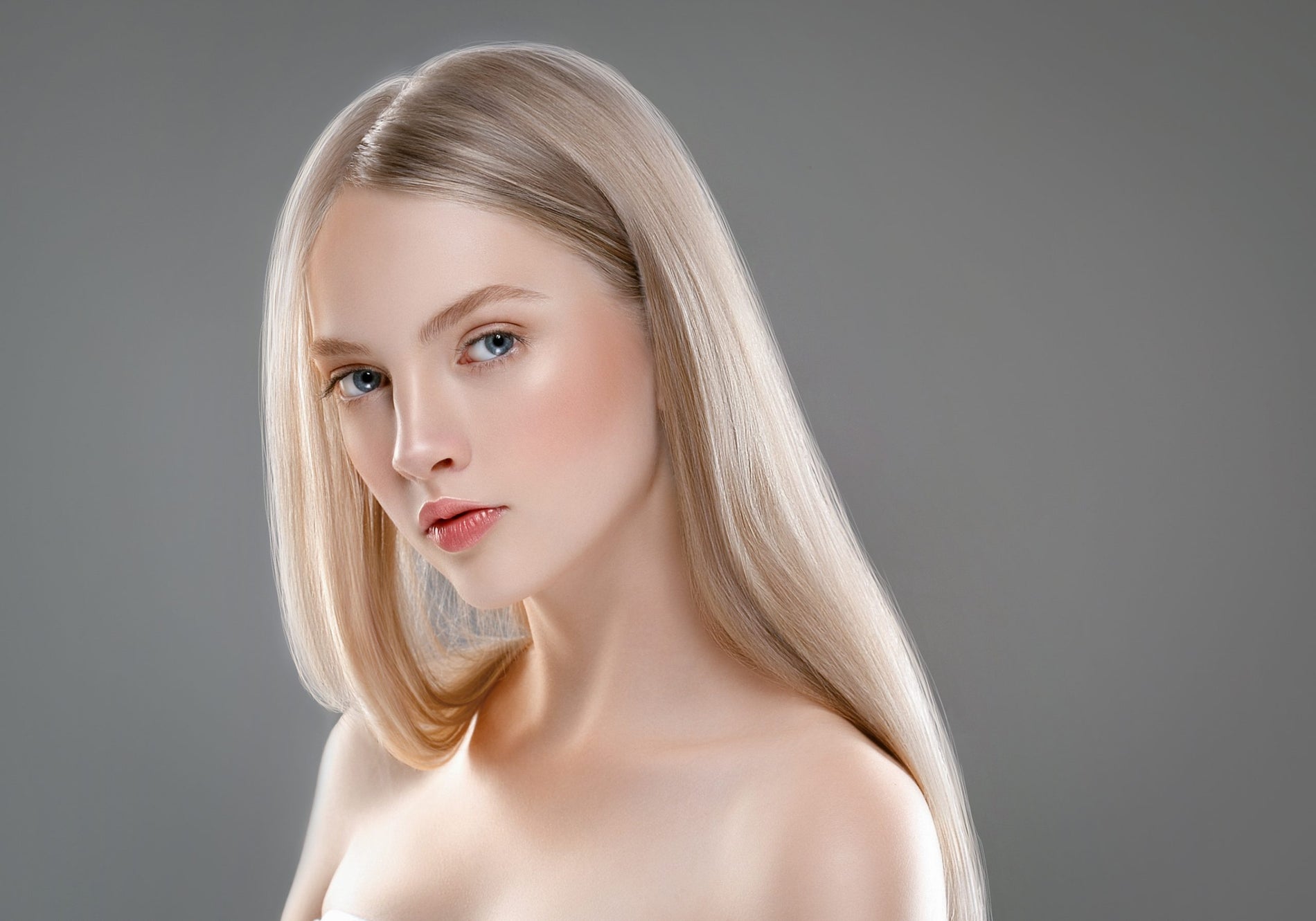 Fioletowy szampon do włosów pozwala uzyskać chłodny blond. Na zdjęciu blondynka z długimi włosami